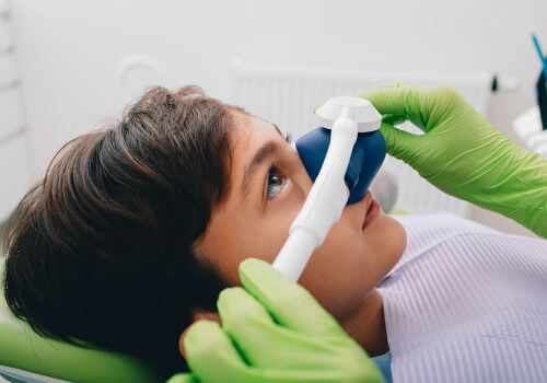 Young boy getting nitrous oxide during dental exam.