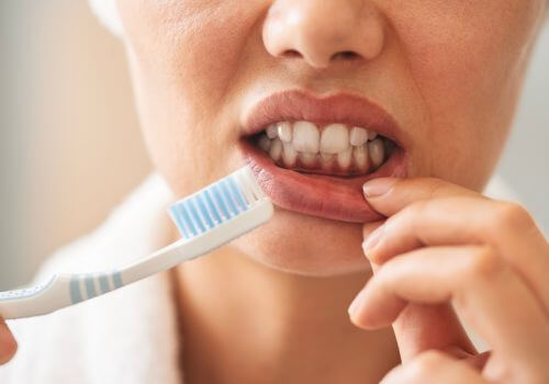 Woman&rsquo;s gums showing irritation after tooth brushing too hard.