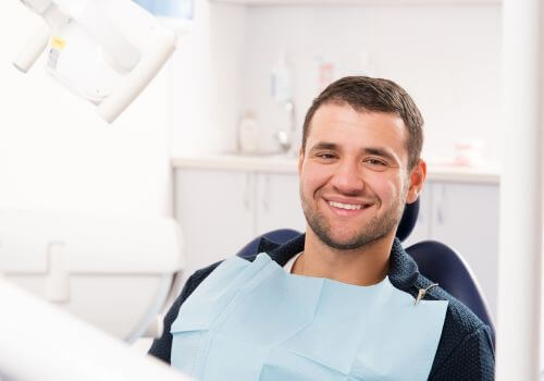 Male patient in dental chair smiling