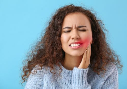 Woman with a tooth ache holder her jaw
