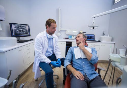Man explaining his dental emergency to a dentist