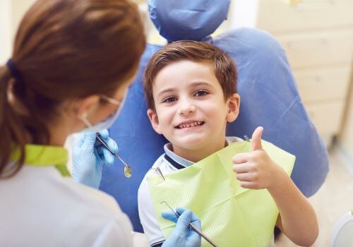 Young boy giving a thumbs up at a childrens dental checkup