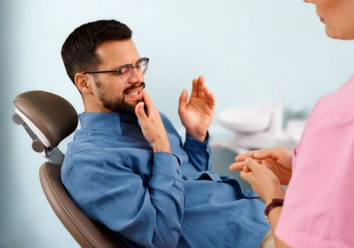 Man at dentist talking about TMJ from stress.