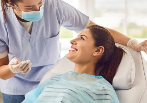 Dentist conducting dental exam on female patient